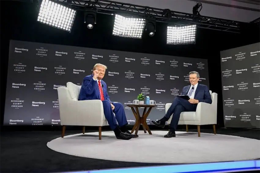 Donald Trump sitting as a guest onstage at an Economic Club of Chicago interview event in October 2024